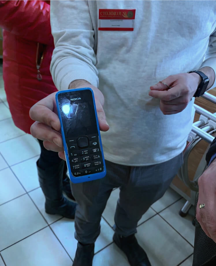 Customer showing a basic Nokia phone used for daily business operations in St. Petersburg
